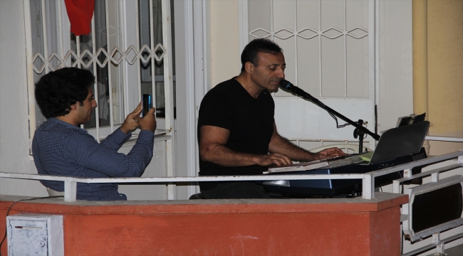 Hatay'da bir müzisyen evinin balkonundan mahalleye konser verdi