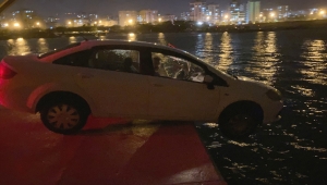 Mersin'de balıkçı barınağının iskelesinde askıda kalan otomobili itfaiye çıkardı