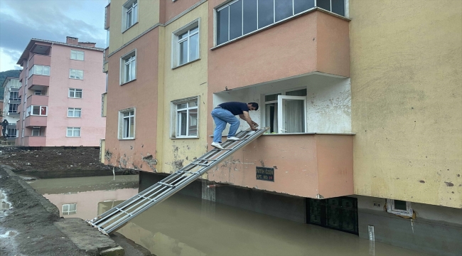 Girişi suyla dolan binaya karyola demirinden kurdukları "köprü"den ulaşıyorlar 